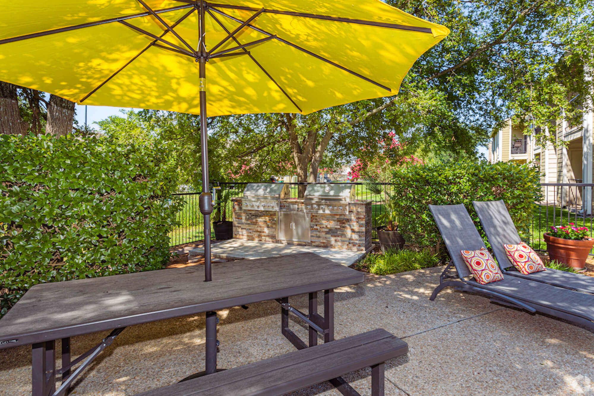 The Avalon Apartments outdoor bbq and grill area with benches and chairs