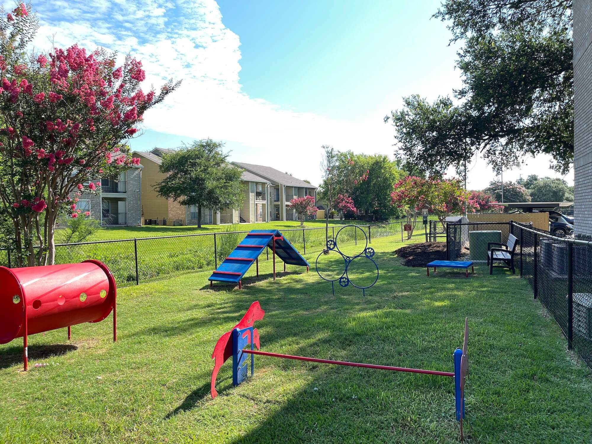 The Avalon Apartments dog park with colorful obstacles 