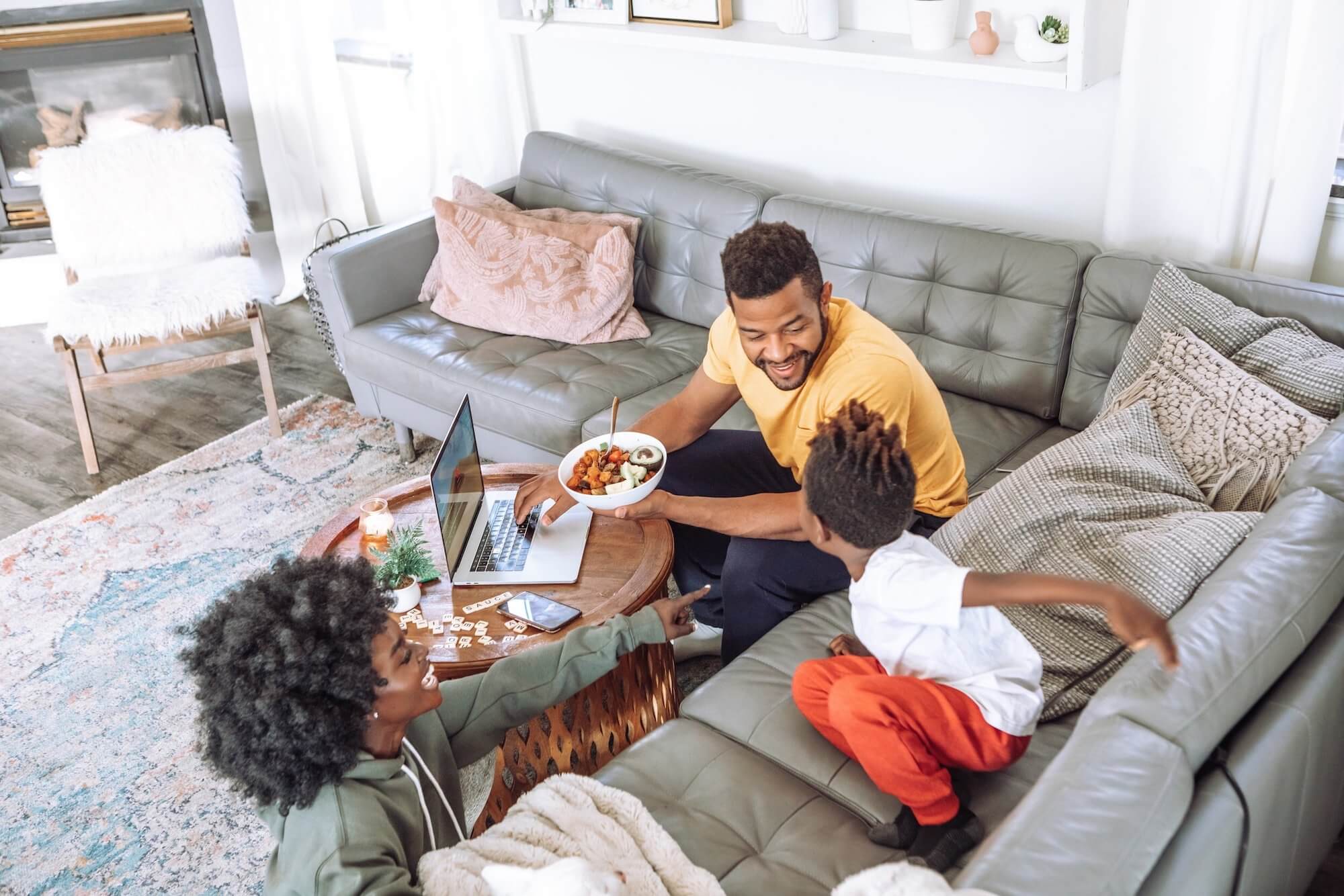 A family snacking and having fun on the couch