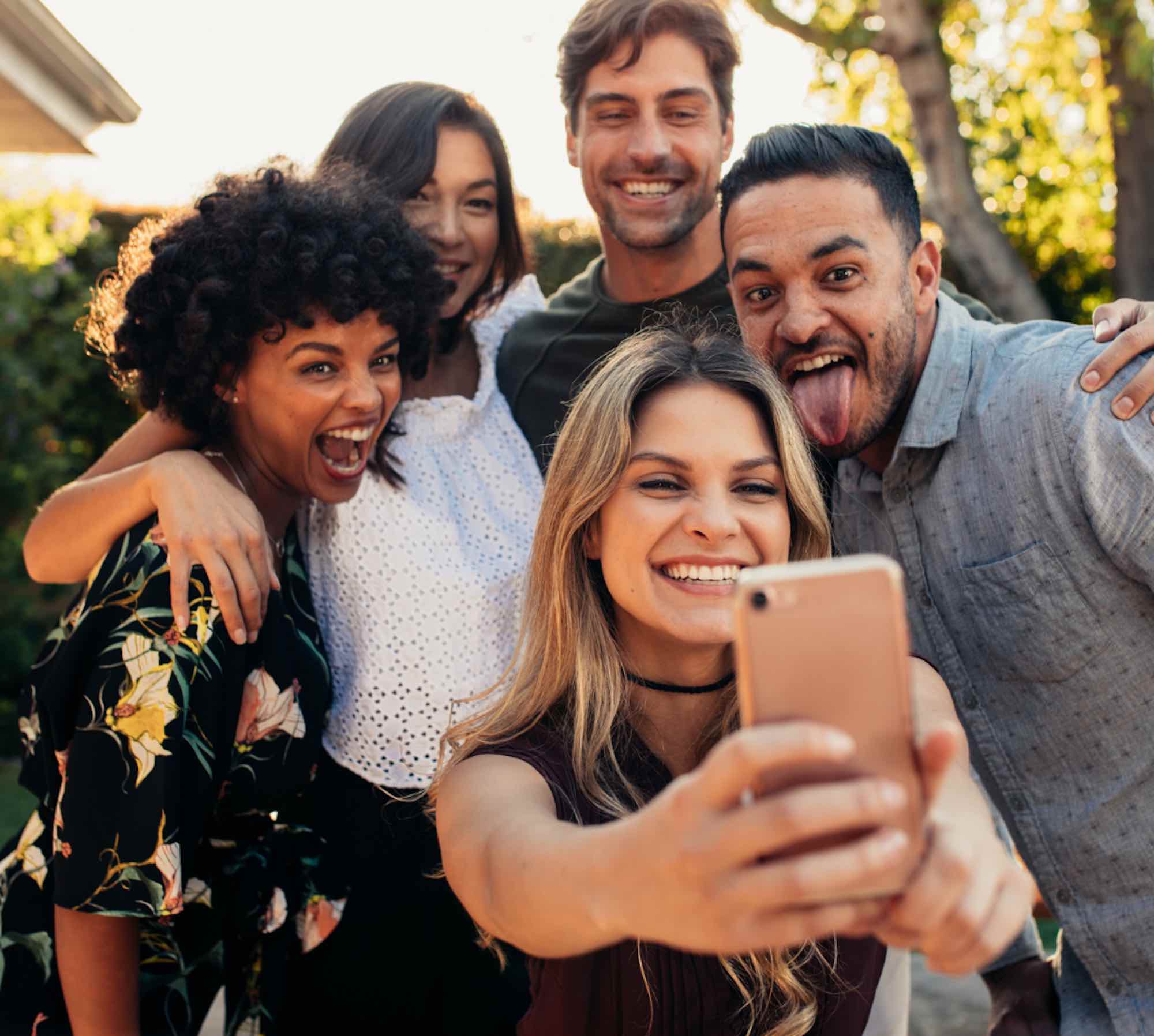 A group of friends grouping up to take a selfie