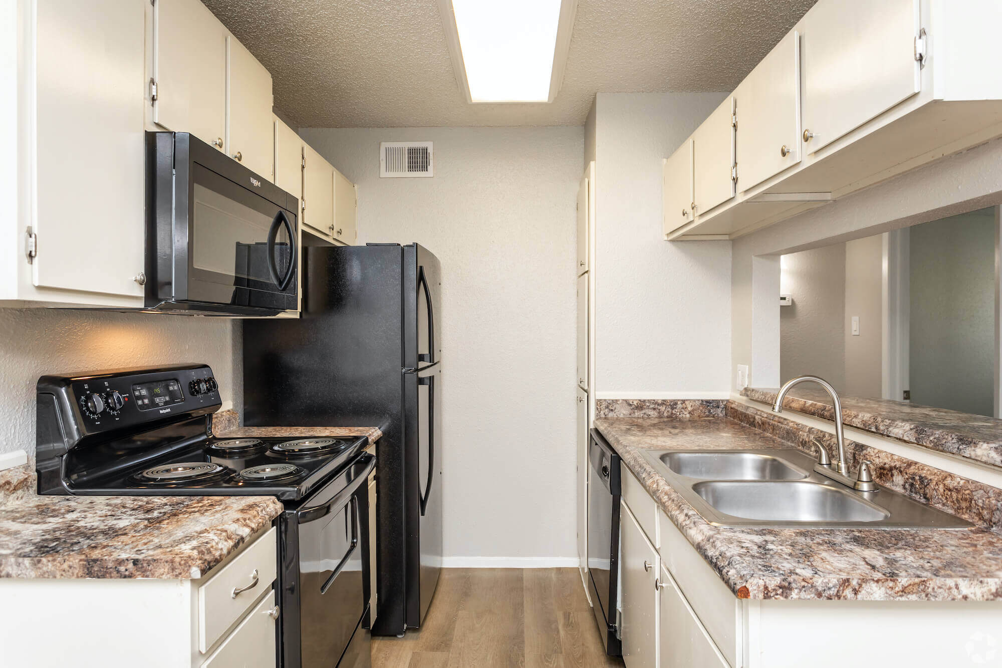 The Avalon Apartments kitchen with black appliances and white cabinetry