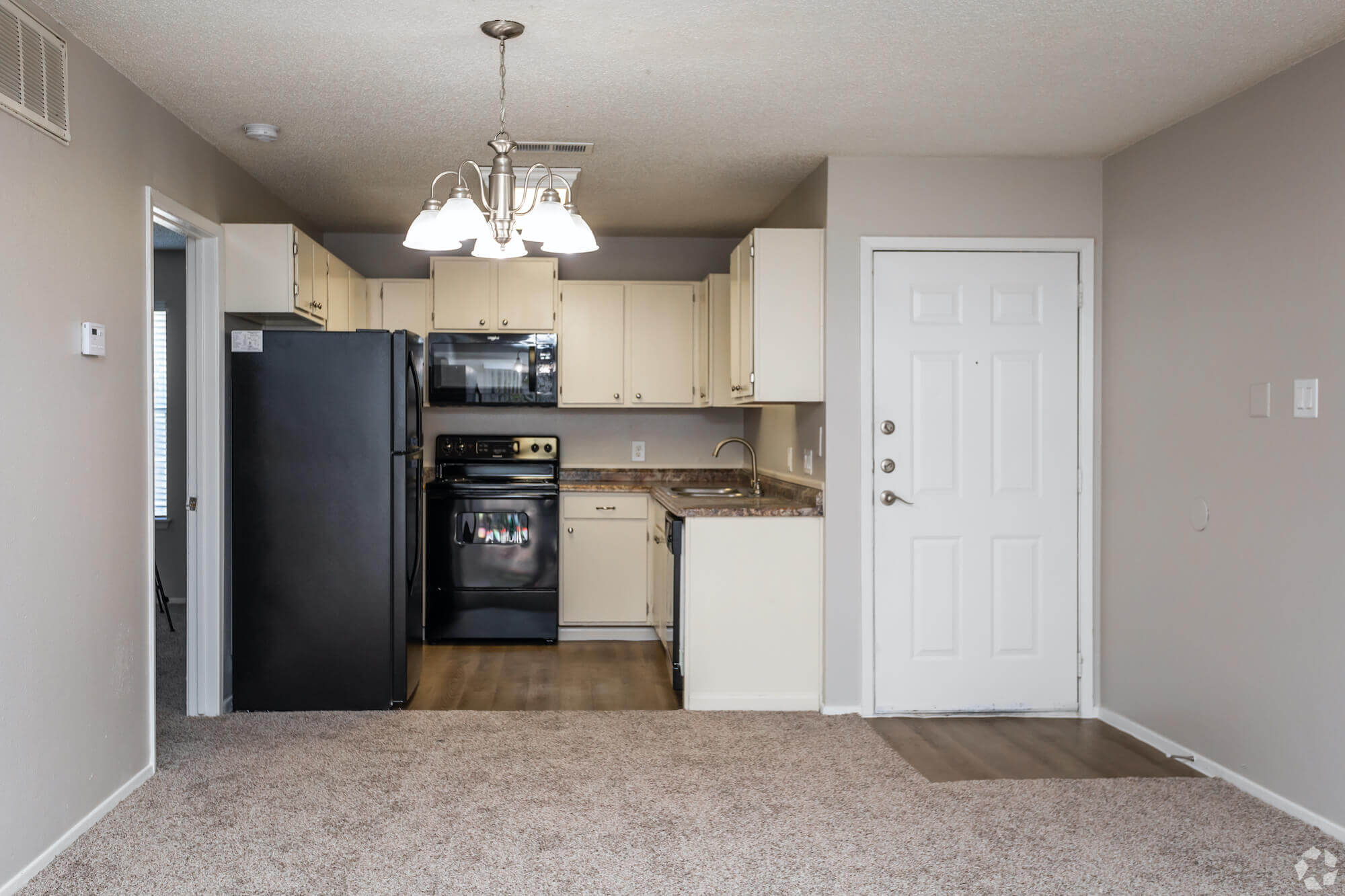 The Avalon Apartments kitchen with white cabinets and black appliances