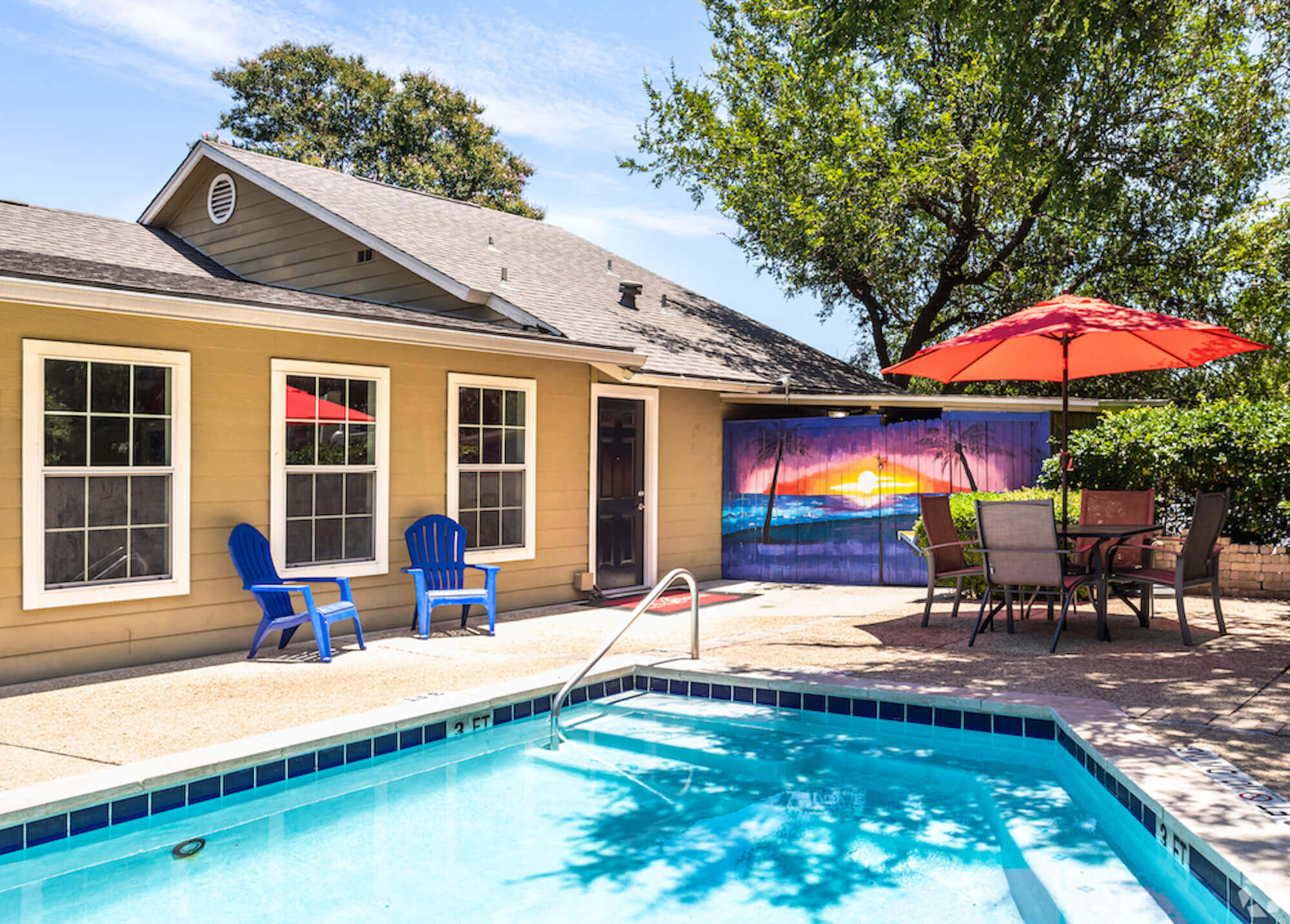 The Avalon Apartments blue pool and sunset mural